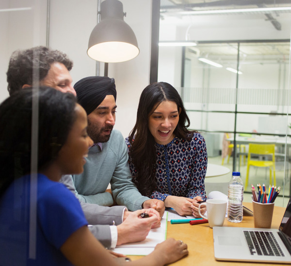 Office Environment People Gathered Around Laptop