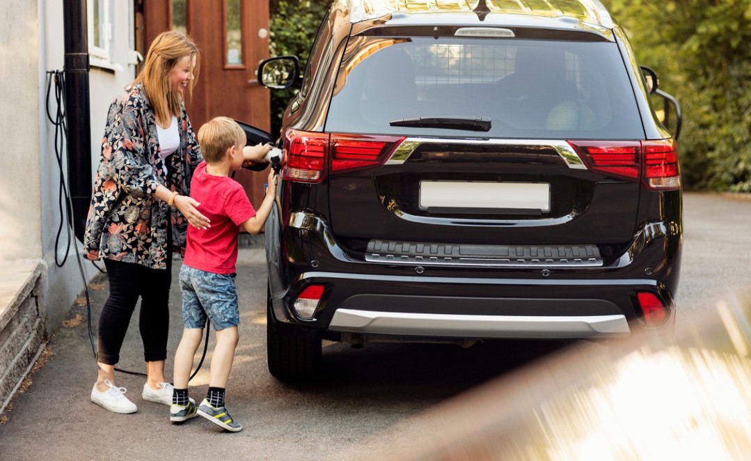 Lady And Child Charging Their Electric Car