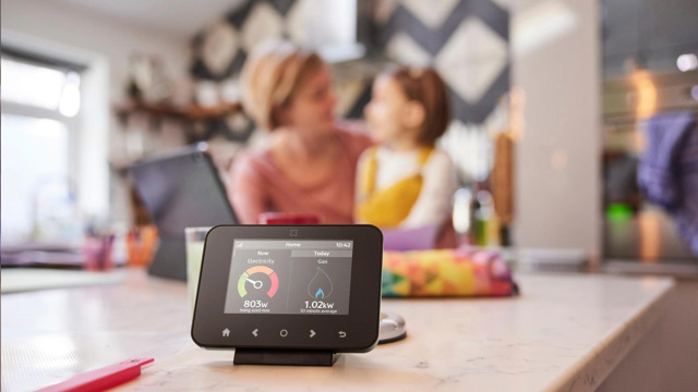 Image Of A Smart Meter In The Foreground With A Mother And Child Sitting In The Background (1)